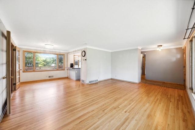 unfurnished living room featuring baseboards, ornamental molding, visible vents, and light wood-style floors