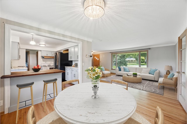 dining room with light wood-style floors and a chandelier