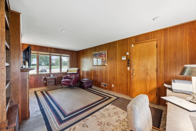 living area featuring visible vents and wooden walls