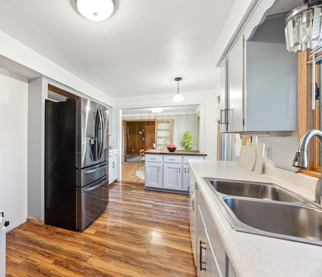 kitchen with dark wood-type flooring, a sink, wood counters, stainless steel fridge with ice dispenser, and decorative light fixtures