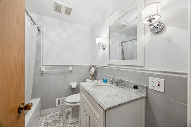 full bath featuring tile patterned flooring, visible vents, tile walls, and vanity