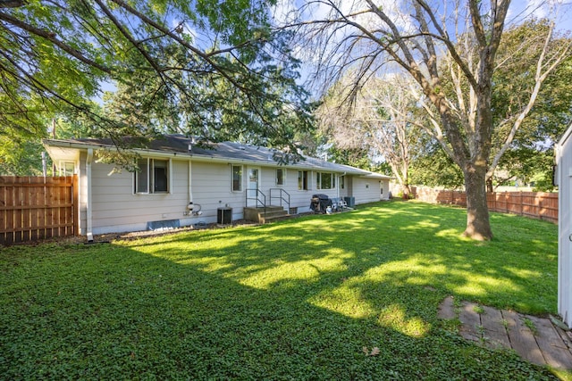 back of property with fence, cooling unit, and a yard