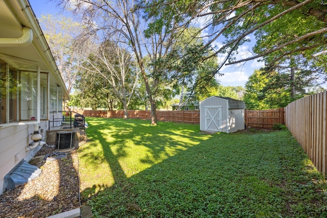 view of yard featuring a fenced backyard, an outdoor structure, central AC, and a shed