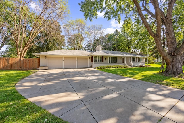 ranch-style home with an attached garage, fence, driveway, a chimney, and a front yard