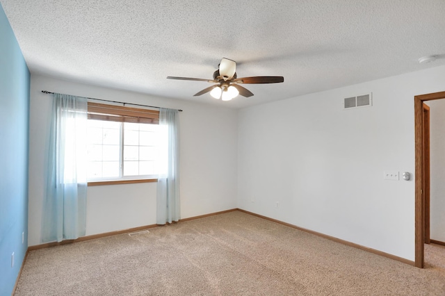 empty room with a ceiling fan, baseboards, visible vents, and carpet flooring