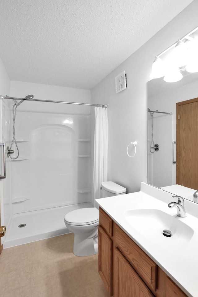 full bathroom featuring visible vents, toilet, a shower with curtain, a textured ceiling, and vanity