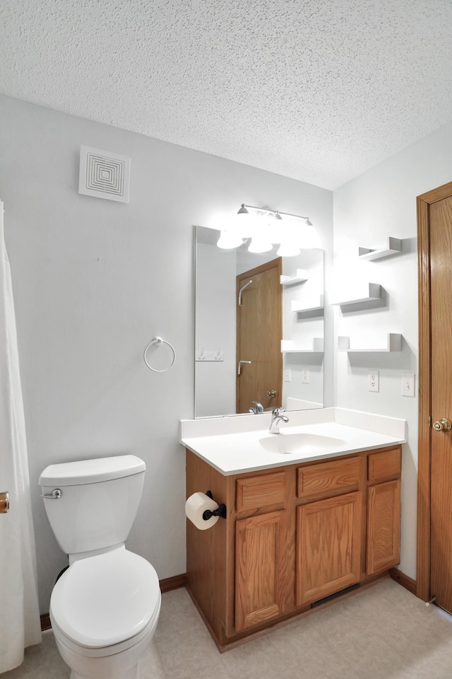 bathroom with toilet, visible vents, a textured ceiling, and vanity