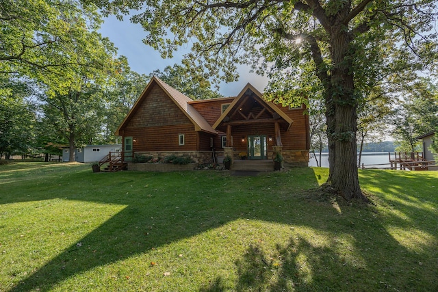 view of front of house featuring stone siding, log veneer siding, and a front yard