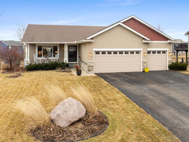 ranch-style house with a porch, a front yard, driveway, and an attached garage