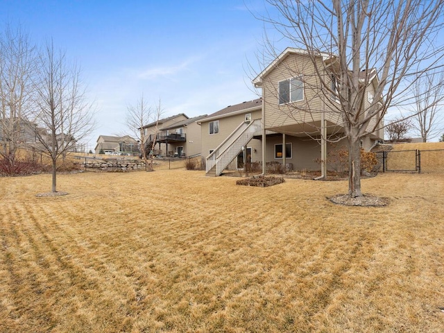 back of property featuring a fenced backyard, stairway, and a yard