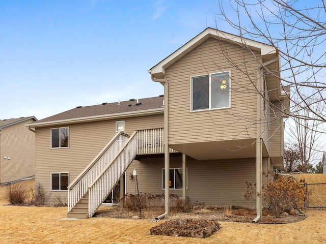 rear view of house featuring a deck, fence, and stairway