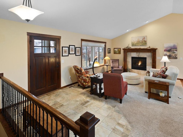 living area featuring lofted ceiling, baseboards, light colored carpet, and a tiled fireplace