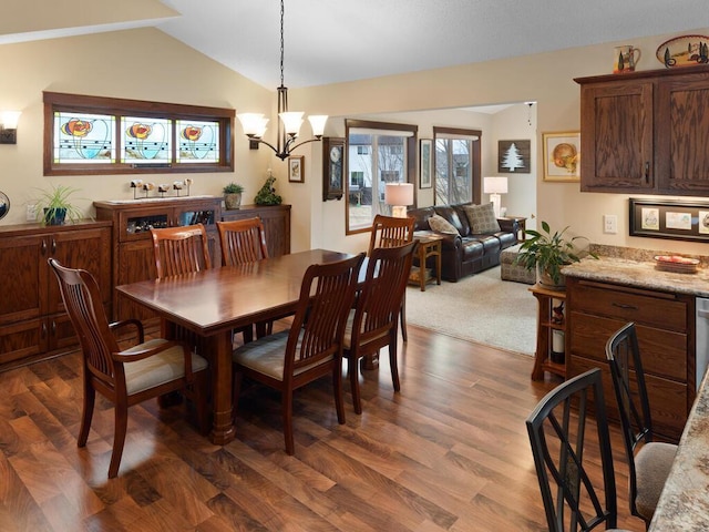 dining area featuring lofted ceiling, dark wood-style floors, and a notable chandelier