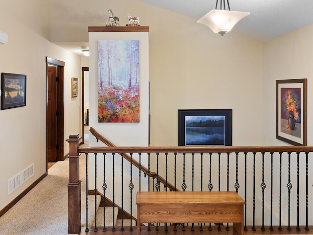 hall featuring visible vents and baseboards