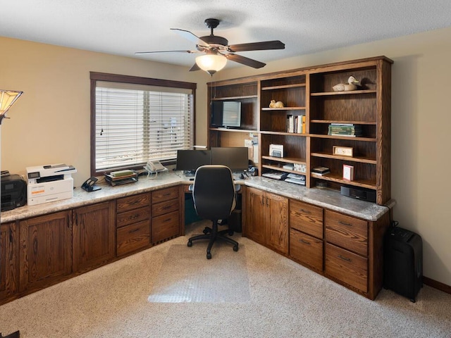 home office featuring light colored carpet, ceiling fan, and a textured ceiling