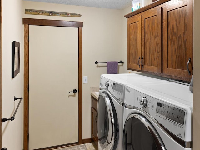 laundry area with cabinet space, a textured ceiling, and independent washer and dryer