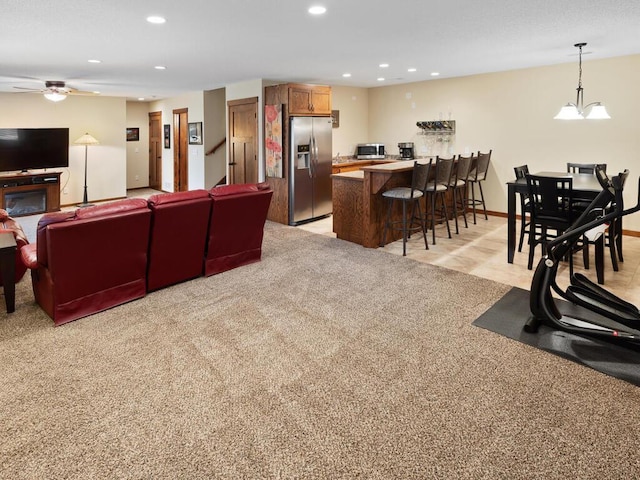 living area featuring ceiling fan, baseboards, light colored carpet, and recessed lighting