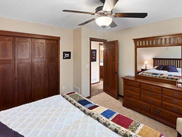 bedroom featuring a closet, light colored carpet, visible vents, ceiling fan, and baseboards