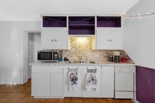 kitchen with white cabinets, dishwasher, stainless steel microwave, a textured ceiling, and a sink