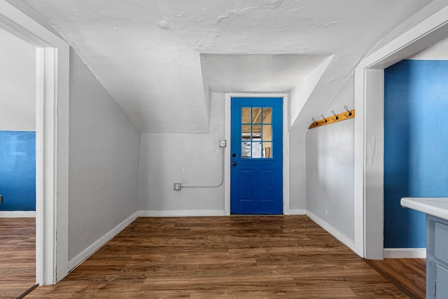 foyer entrance with lofted ceiling, a textured ceiling, baseboards, and wood finished floors