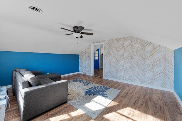 interior space featuring baseboards, visible vents, vaulted ceiling, and wood finished floors