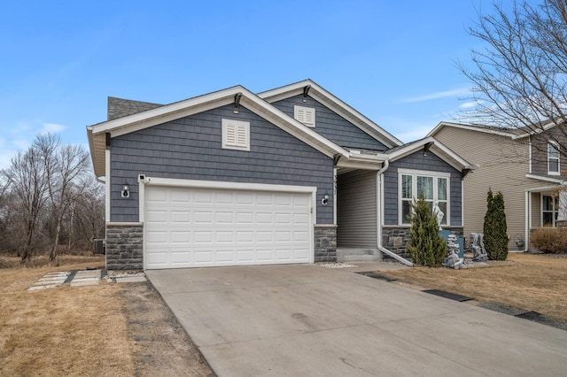 craftsman-style house featuring stone siding, driveway, and a garage