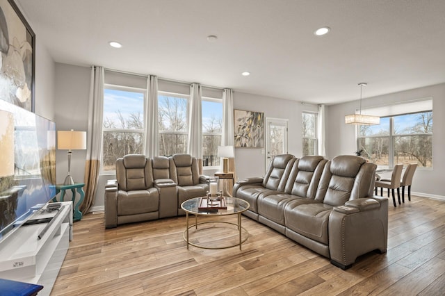 living room with recessed lighting, a notable chandelier, baseboards, and light wood-style floors