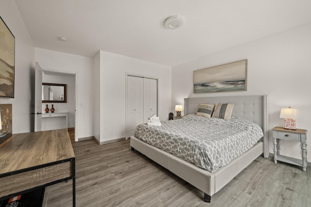 bedroom with a closet, baseboards, and wood finished floors