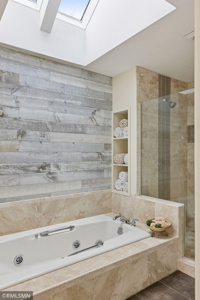 bathroom with built in shelves, a skylight, a stall shower, tile patterned flooring, and a whirlpool tub