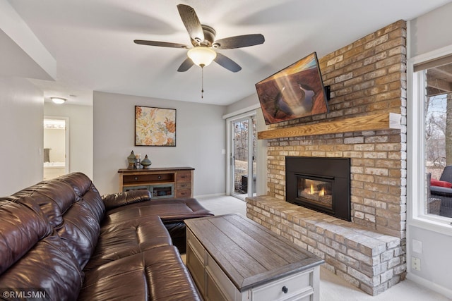 carpeted living room featuring a fireplace, baseboards, and a wealth of natural light