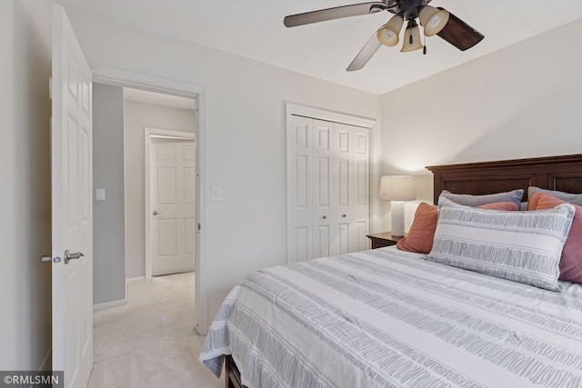 bedroom featuring light carpet, ceiling fan, baseboards, and a closet