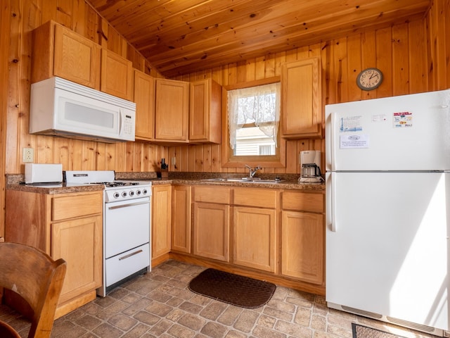 kitchen with white appliances, dark countertops, wooden ceiling, wood walls, and a sink