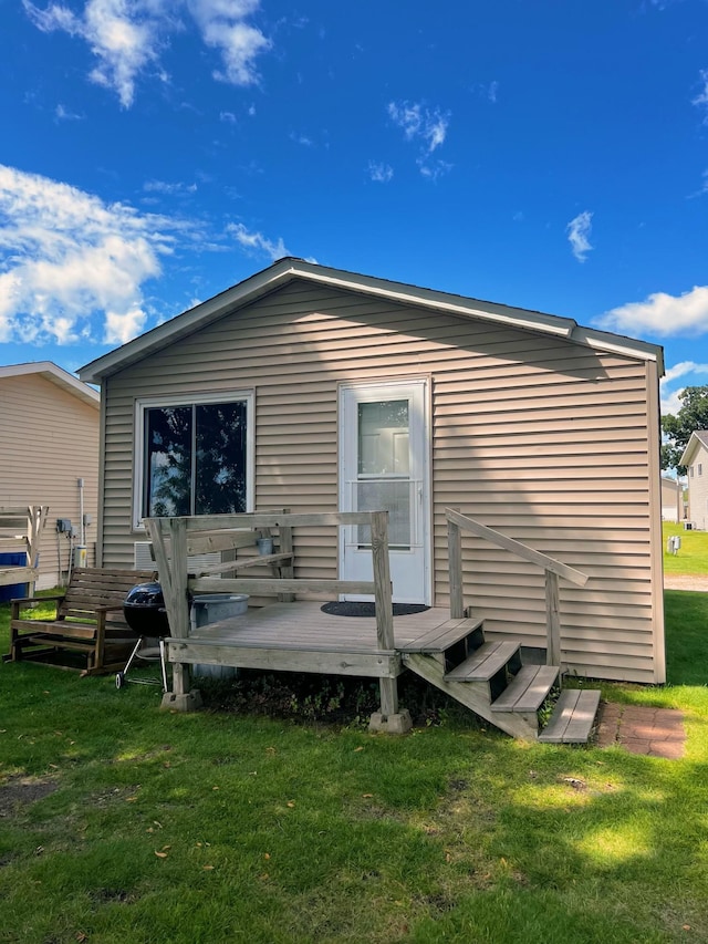 back of property with a lawn and a wooden deck