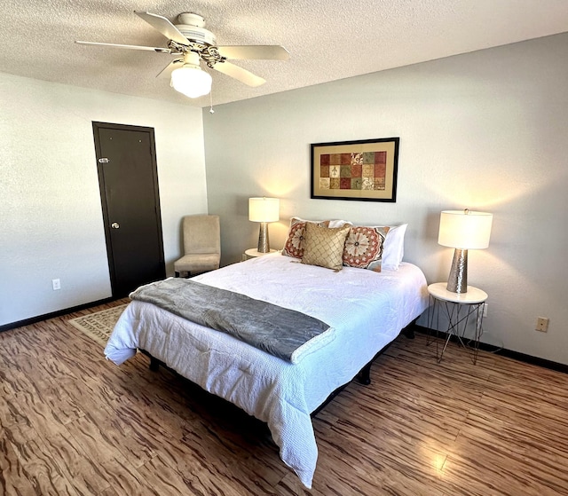 bedroom featuring a textured ceiling, ceiling fan, wood finished floors, and baseboards