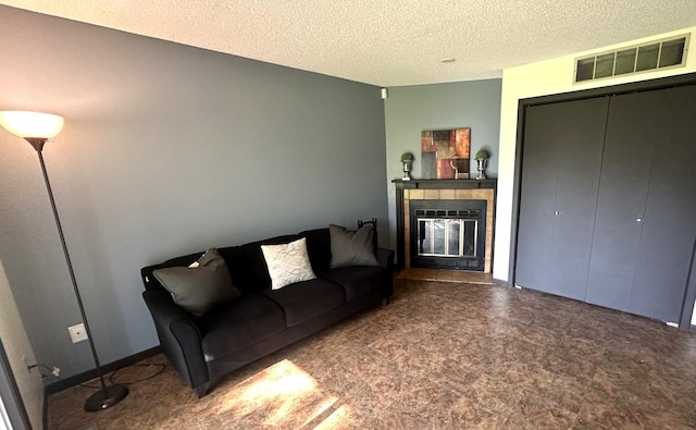 living area featuring visible vents, a fireplace, and a textured ceiling