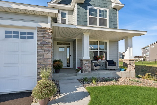 entrance to property with an attached garage, stone siding, and a porch