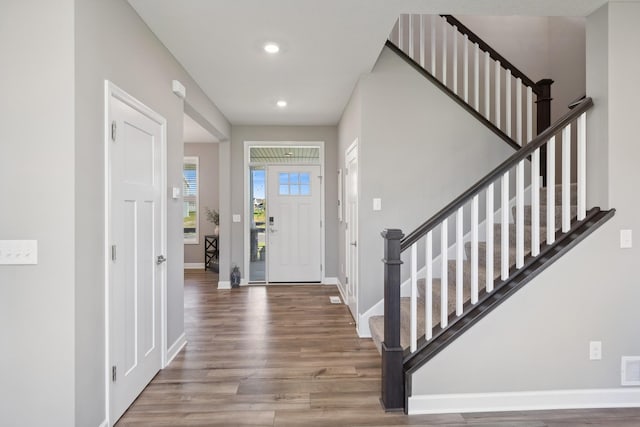 entrance foyer featuring recessed lighting, wood finished floors, visible vents, baseboards, and stairway