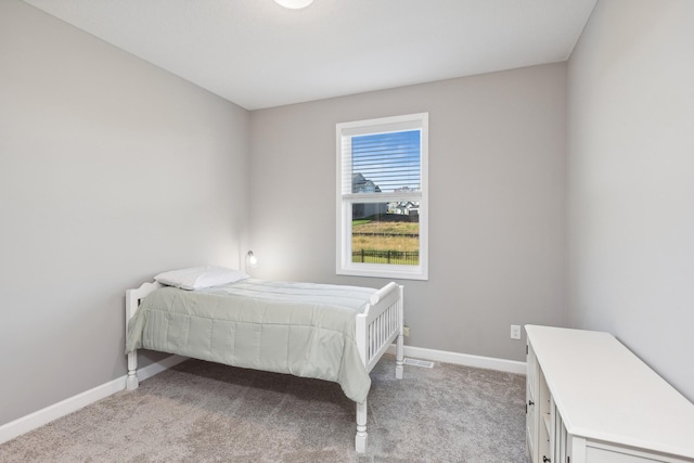 bedroom with light carpet and baseboards