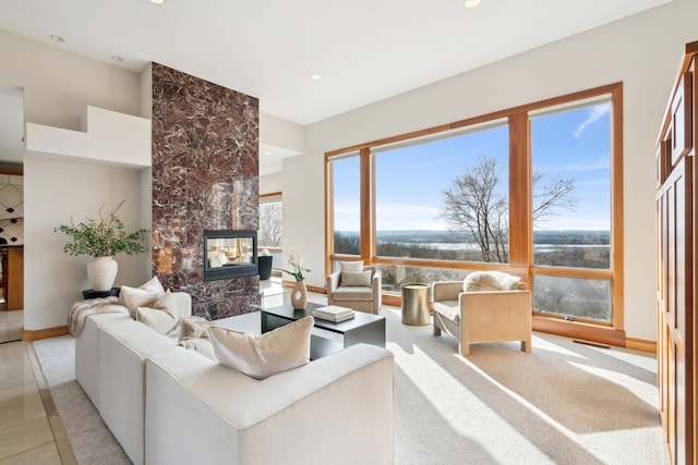 living room with light tile patterned floors, recessed lighting, baseboards, and a tile fireplace