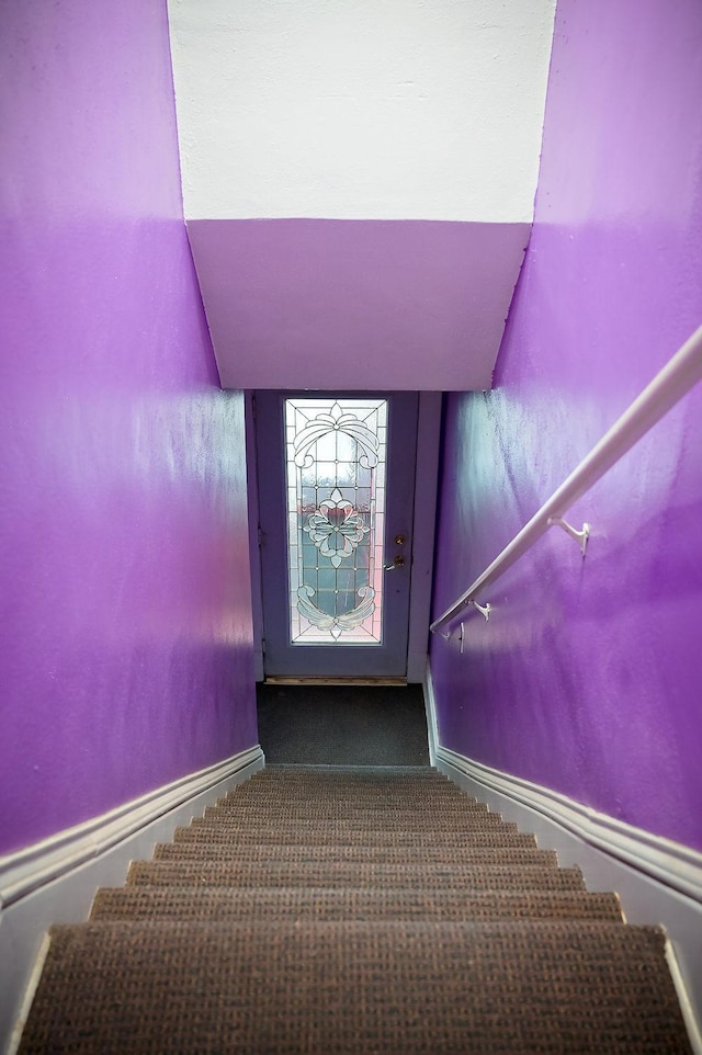 staircase with carpet floors and baseboards