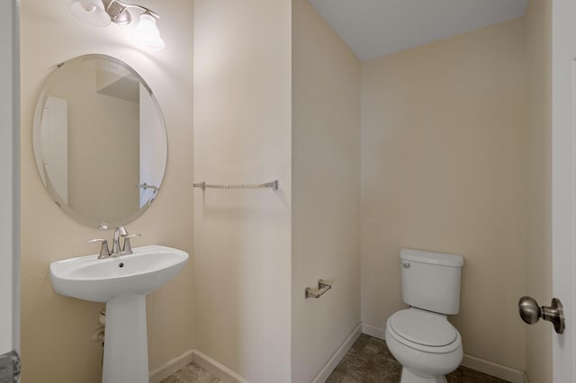 bathroom with toilet and baseboards