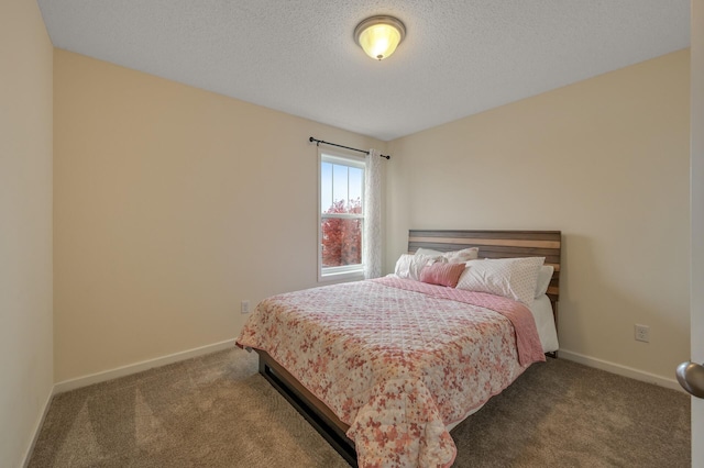 bedroom with a textured ceiling, carpet floors, and baseboards