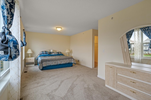 carpeted bedroom with visible vents and baseboards