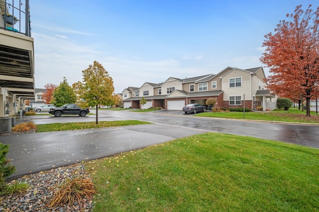 view of yard featuring a residential view, cooling unit, and driveway