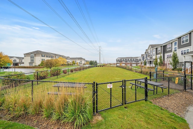 exterior space featuring a gate, a residential view, and fence