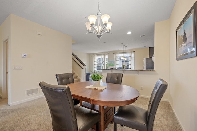 dining area with light colored carpet, visible vents, an inviting chandelier, baseboards, and stairs