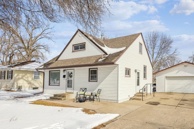 view of front of property featuring a shingled roof, an outdoor structure, and a detached garage