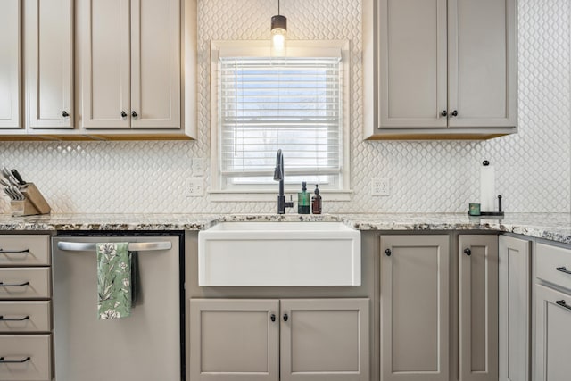 kitchen featuring tasteful backsplash, gray cabinets, a sink, and stainless steel dishwasher