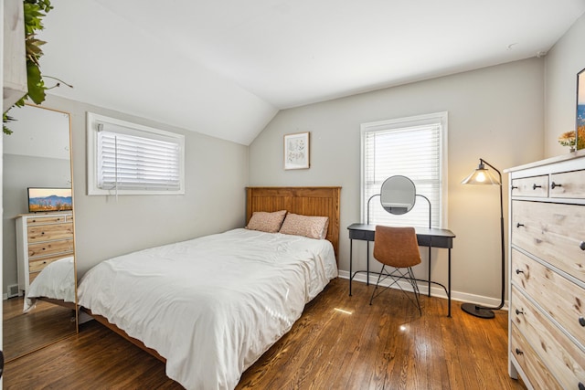 bedroom with baseboards, vaulted ceiling, and dark wood-type flooring