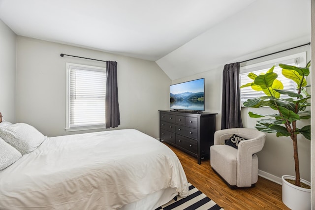 bedroom featuring vaulted ceiling, baseboards, and wood finished floors